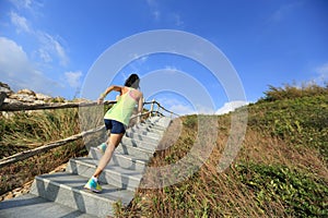 Fitness woman trail runner running up on mountain stairs