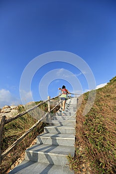 Fitness woman trail runner running up on mountain stairs