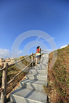 Fitness woman trail runner running up on mountain stairs