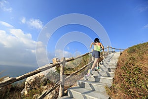 Fitness woman trail runner running up on mountain stairs