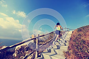 Fitness woman trail runner running up on mountain stairs