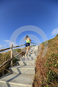 Fitness woman trail runner running up on mountain stairs