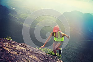 Fitness woman trail runner running up to mountain top