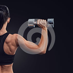 Fitness woman in training muscles of the back with dumbbells