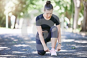 Fitness, woman tying her shoelaces and running outdoors at a nature park. Workout or exercise, training or health