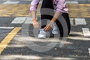 Fitness woman tying shoelaces, body only