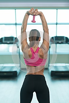 Fitness Woman Using Dumbbell Exercising Triceps Inside Gym