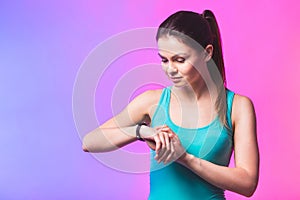 Fitness woman using fitness tracker on wrist over white background. A woman using a smartwatch. Healthy lifestyle. Copy space