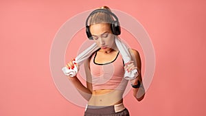 Fitness Woman In Wireless Headphones Listening To Music, Pink Background
