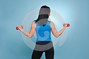 Fitness woman working out with dumbbells.