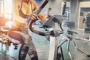 Fitness woman working out on exercise bike at the gym