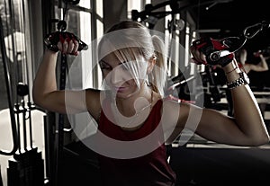 Fitness woman working out in gym doing exercise for biceps. Athletic girl training .Beautiful fitness woman lifting