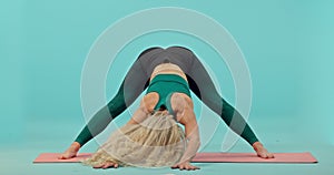 Fitness, woman and yoga stretching on mat for workout, exercise or training against a blue studio background. Active