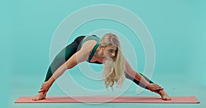 Fitness, woman and yoga stretching in studio for healthy workout, exercise or training against a blue background. Active