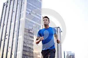 Fitness, workout and man running in the city for health, wellness or training for a marathon. Sports, runner and male
