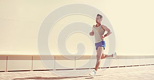 Fitness, workout, sport and healthy lifestyle concept - sportsman running in the city on a sunny day