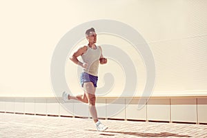 Fitness, workout, sport, lifestyle concept - sportsman running in a city