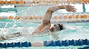 Fitness, workout and a swimmer in a pool during a race, competition or cardio training at a gym. Exercise, water and