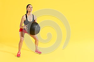 Fitness workout. Woman exercising squats with med ball at studio