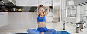 Fitness, yoga and gym at home concept. Young woman doing stretching workout, exercising in living room, fitness training