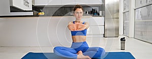 Fitness, yoga and gym at home concept. Young woman doing stretching workout, exercising in living room, fitness training