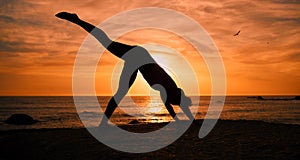 Fitness, yoga and silhouette of woman at sunrise on beach for exercise, training and pilates workout. Morning