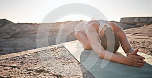 Fitness, yoga and woman on rocks at beach stretching, meditation and training in nature for healthy lifestyle. Health