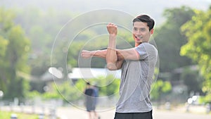 Fitness young asian man in sportswear warming up before jogging in the morning