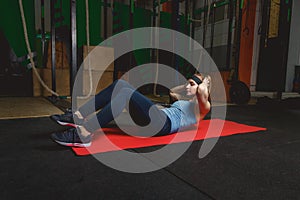 Fitness young girl in the gym doing exercises with abdominals. Crossfit