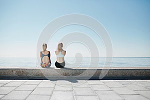 Fitness young girls relaxing after running in city.