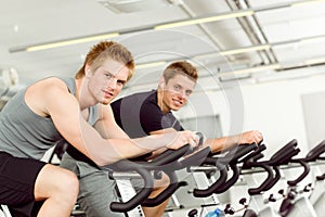 Fitness young man on gym bike spinning