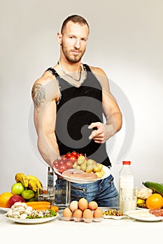 Fitness young man presenting his healthy diet for powerfull body