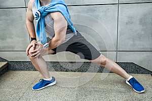 Fitness young man in sportswear doing yoga. Close up blue shoe
