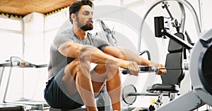 Fitness young man using rowing machine