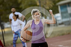 Fitness young woman with basketball ball playing game outdoor