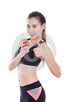 Fitness young woman holding apple and showing thumb up