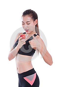 Fitness young woman holding apple and showing thumb up