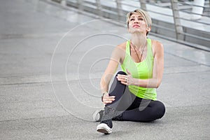 fitness young woman Running injury leg accident of workout exercising on street in urban city . sport runner girl sitting on floor