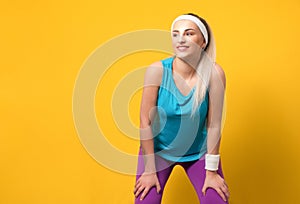 Fitness young woman wearing sportswear,sport clothing, posing and looking to side while keeps her arms on legs,leg, isolated on