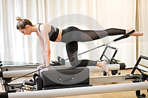 Fitted woman doing diagonal stabilization with strap photo