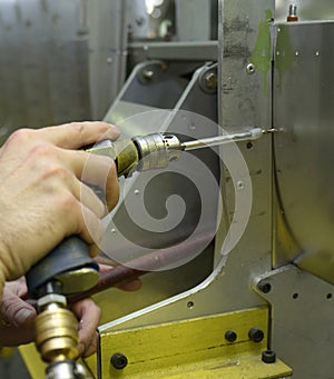 Fitter hands working with a pistol type pneumatic drill