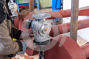 Fitter installs a gas shutoff valve in the boiler room photo