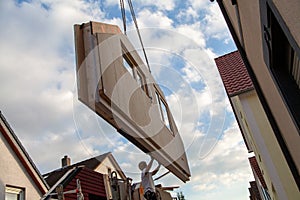 A fitter moves a prefabricated house component with the crane