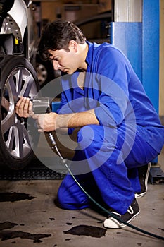 Fitting some new tyres. A male mechanic working on the wheel of a car.