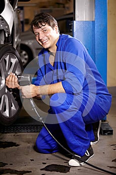 Fitting your new tyres. Portrait of a male mechanic working on the wheel of a car.