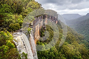 Fitzroy water falls thundering over rock face into forested canyon in Kangaroo Valley, photo
