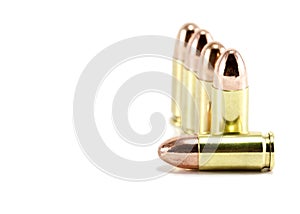Five 9mm bullets on white photo