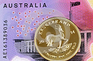 A five Australian dollar bill with a South African golden Krugerrand coin