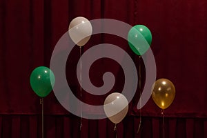 Five balloons of different colors on a red background. For decoration design of the holiday.