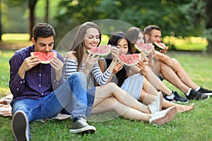 Five beautiful young people eating juicy ripe watermelon outdoor